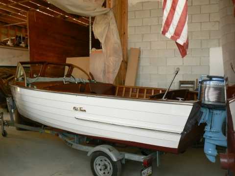 Un petit bateau à moteur uipé d' un vieux moteur Mercury